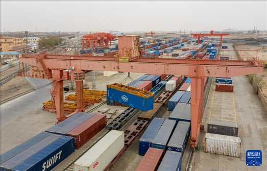 4月21日，二連浩特鐵路口岸龍門(mén)吊吊裝中歐班列集裝箱（無(wú)人機(jī)照片）。 新華社發(fā)（張海峰攝）