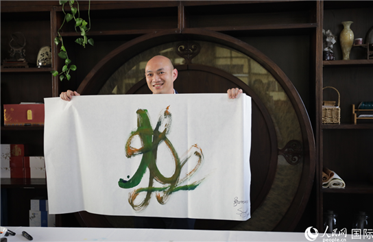 老撾駐華大使館三秘明君參加《五百筆·瀾湄合作》集體藝術創(chuàng)作。人民網王婧攝。