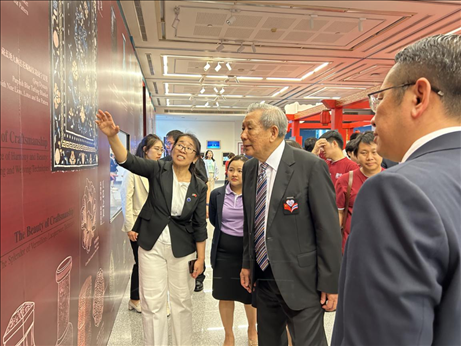 工作人員為泰國前副總理、泰中文化促進委員會主席披尼講解展覽內(nèi)容。中國駐泰國大使館供圖