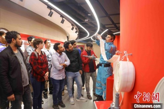 5月9日，工作人員指導(dǎo)留學(xué)生正確使用消防水帶。張鷹 攝