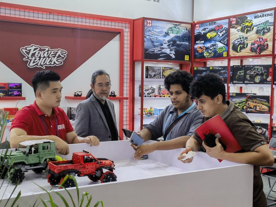 在第135屆廣交會第三期現場，采購商在廣東信宇科技股份有限公司展位選購、體驗積木遙控車產品（5月2日攝）。新華社記者 洪澤華 攝