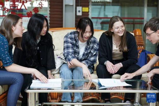 4月28日，宋智孝（右二）和胡靈月（左一）在北京首都師范大學(xué)校園內(nèi)與同學(xué)交流。新華社記者 彭子洋 攝