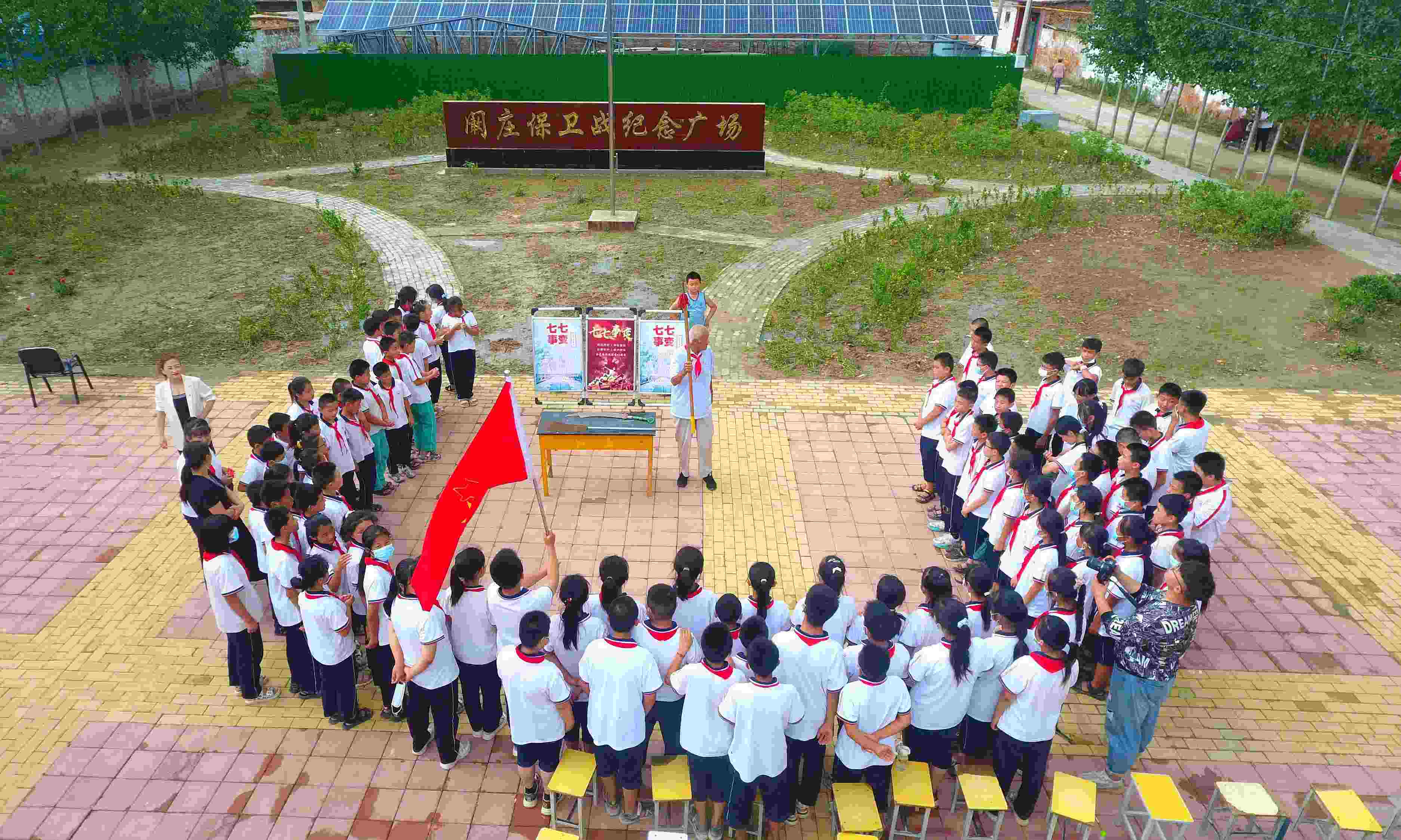 2022年7月6日，山東省聊城市，在茌平區(qū)菜屯鎮(zhèn)闞莊村的闞莊保衛(wèi)戰(zhàn)紀(jì)念廣場(chǎng)，闞莊保衛(wèi)戰(zhàn)親歷者王光木老人為小學(xué)生們講述抗戰(zhàn)故事，展示大刀、長(zhǎng)矛。