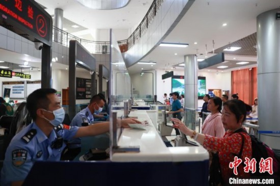 圖為旅客在磨憨口岸辦理通關(guān)手續(xù)。雷雨 攝