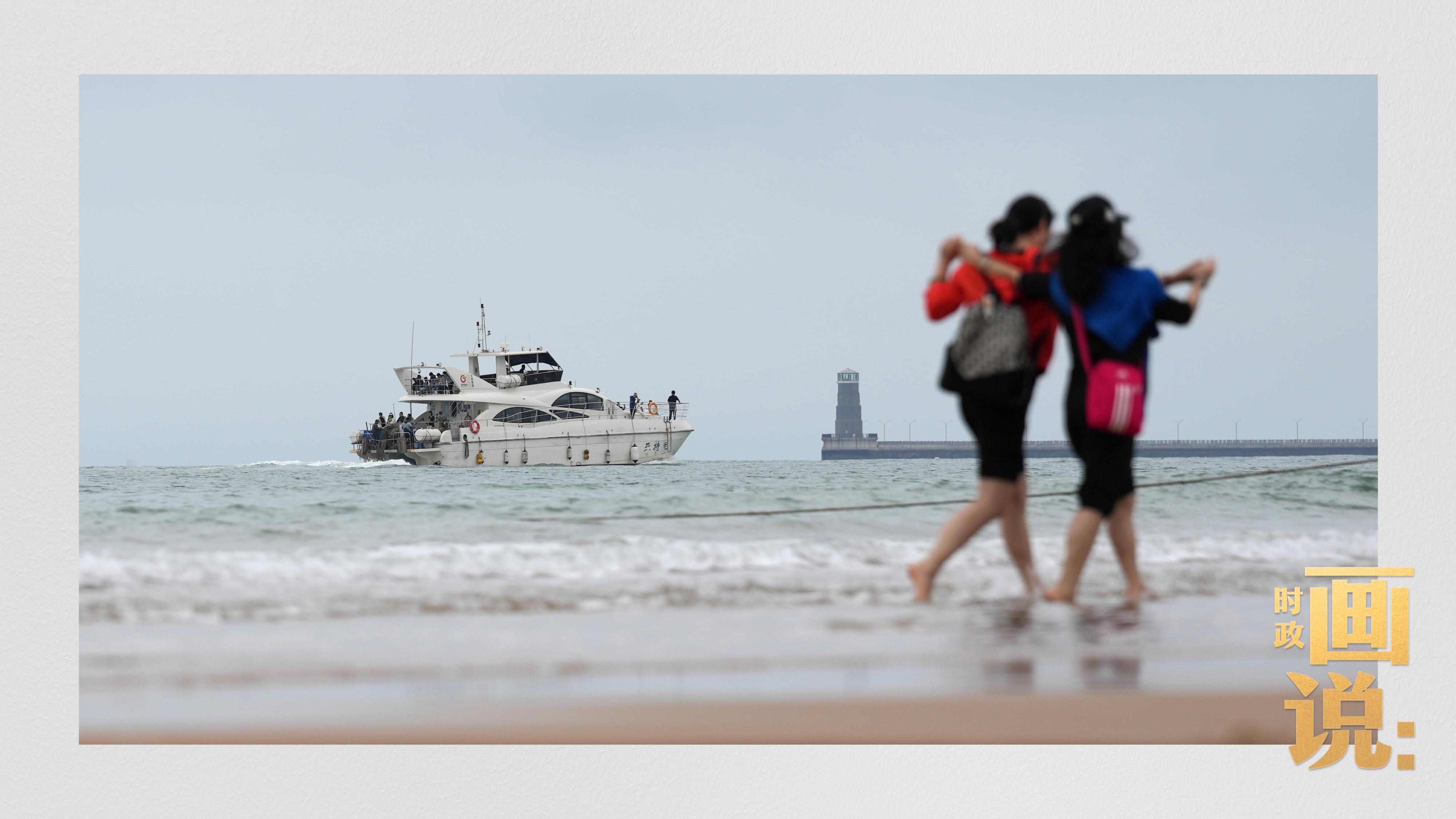 △日照陽光海岸綠道上的萬平口景區(qū)，一對游客在海浪中翩然起舞。