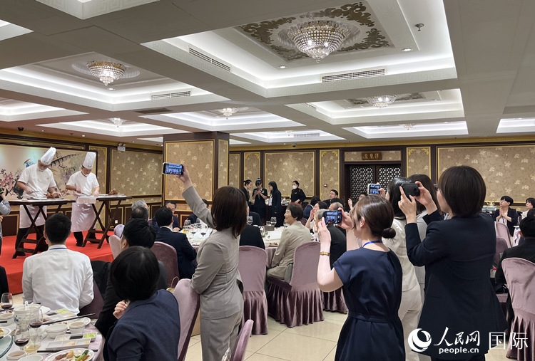 國(guó)家級(jí)非物質(zhì)文化遺產(chǎn)、全聚德片鴨工藝吸引代表團(tuán)成員拍照留念。