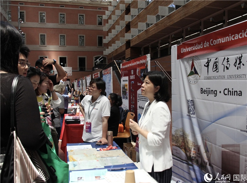 旅西華人華僑在展臺(tái)前咨詢。人民網(wǎng)記者 許海林?jǐn)z