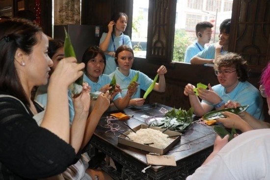 6月9日，美國青年代表在重慶永川松溉古鎮(zhèn)體驗包粽子。新華社記者 周思宇 攝