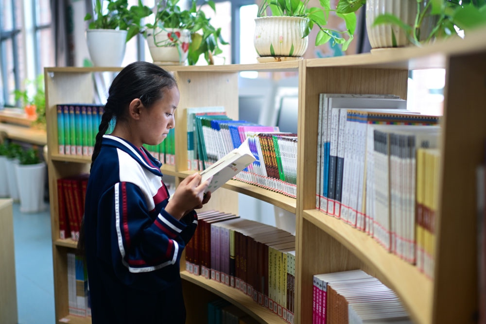 6月18日，果洛西寧民族中學(xué)學(xué)生尼東拉毛在圖書室看書。