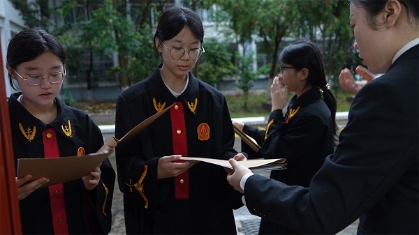 圖①：武平法院干警向學生分發(fā)道具卷宗。