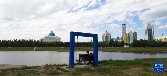 6月30日，一名女子在哈薩克斯坦首都阿斯塔納伊希姆河畔休息。新華社記者 王建華 攝