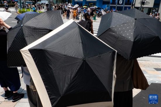 7月4日，人們?cè)谌毡緰|京原宿的街道上等待紅綠燈。新華社記者 張笑宇 攝