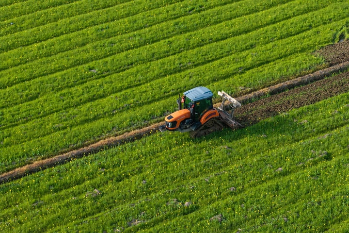 2024年3月19日，在湖南省常德市鼎城區(qū)謝家鋪鎮(zhèn)港中坪村，村民駕駛農(nóng)機翻耕田地（無人機照片）。新華社記者 陳思汗 攝