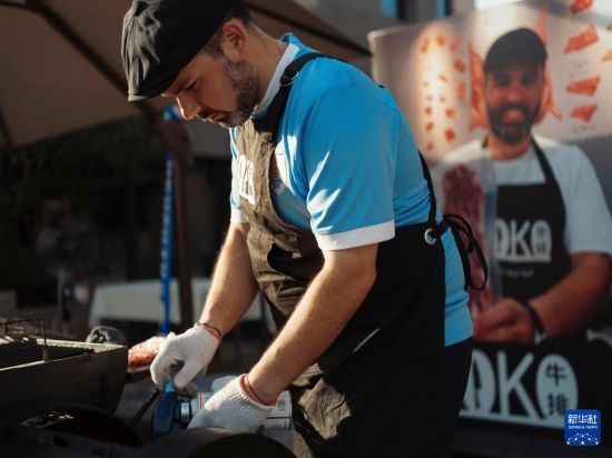 7月19日，在蕪湖古城，馬丁在當天舉行的啤酒節(jié)上制作牛排。新華社發(fā)（繆雨晨 攝）