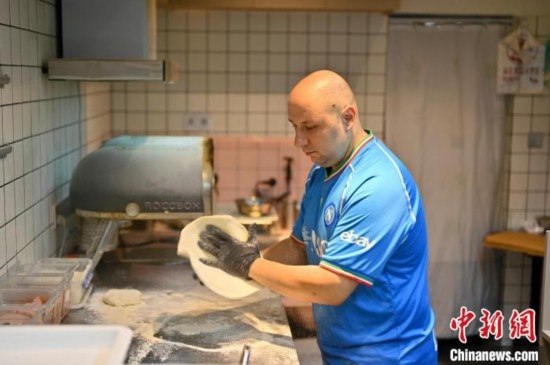 近日，韋榮耀在自家披薩小店內(nèi)忙活。俞靖 攝