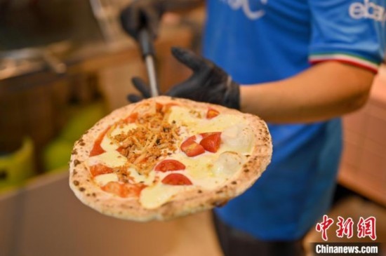 近日，韋榮耀展示他制作的“老友味”披薩。 俞靖 攝