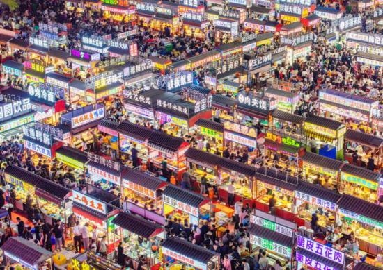 2024年4月21日，人們?cè)诤颖笔≌h小商品夜市品嘗美食（無人機(jī)照片）。新華社發(fā)（武志偉 攝）