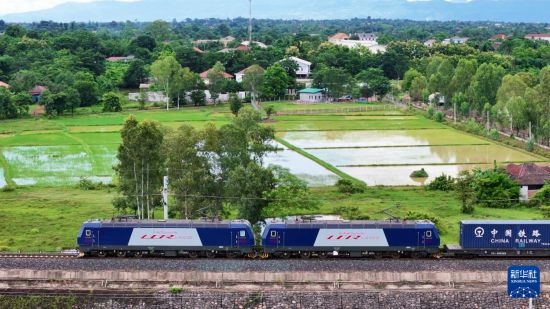 8月5日，由老撾籍火車司機(jī)獨(dú)立駕駛的滿載貨物的列車駛出萬象站，向中國昆明進(jìn)發(fā)（無人機(jī)照片）。新華社發(fā)（楊永全 攝）