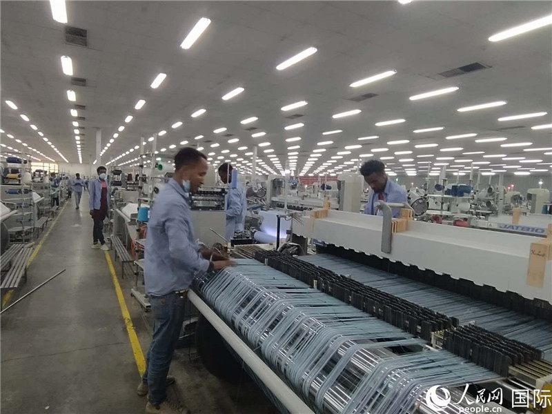 無錫金茂埃塞面料廠車間內，當?shù)毓と苏谝唤z不茍地作業(yè)。人民網(wǎng)記者 黃培昭攝