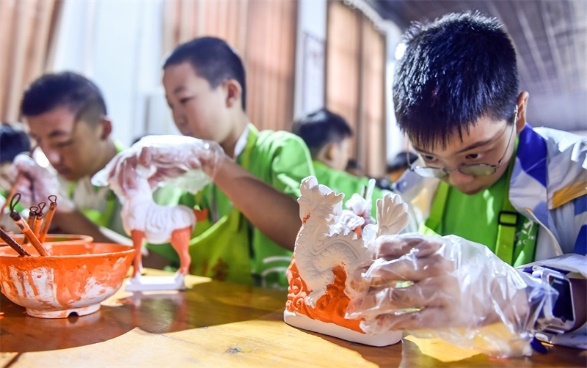 小朋友們?cè)诼尻柺忻辖騾^(qū)朝陽鎮(zhèn)南石山村體驗(yàn)唐三彩素胎施釉技藝。圖片來源：視覺中國