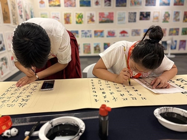 參加本次展覽的青少年在現(xiàn)場進行書法創(chuàng)作。主辦方供圖