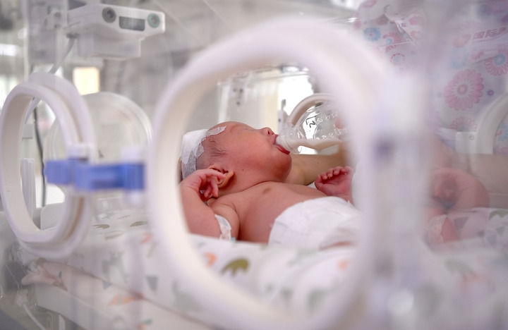 2024年6月1日，在西安國際醫(yī)學中心醫(yī)院新生兒科病房，護士為新生兒喂奶。 新華社記者 劉瀟 攝