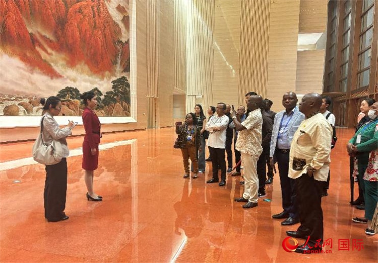 代表團在入口處聽取講解。人民網(wǎng) 曹欣悅攝