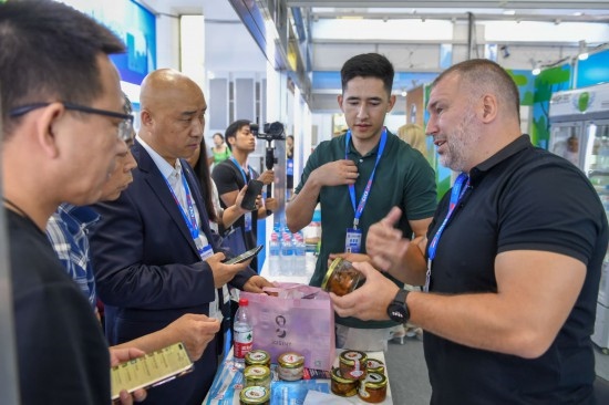 2023年8月23日，在第十四屆中國—東北亞博覽會東北亞商品館，俄羅斯參展商向參觀者介紹商品。