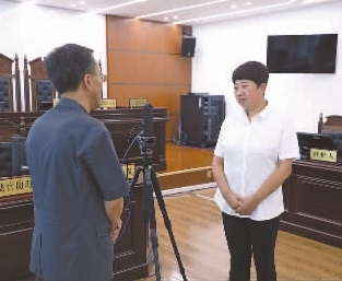 圖為全國人大代表玉明姬（右）詳細(xì)了解環(huán)境資源審判工作情況。劉思妤 攝