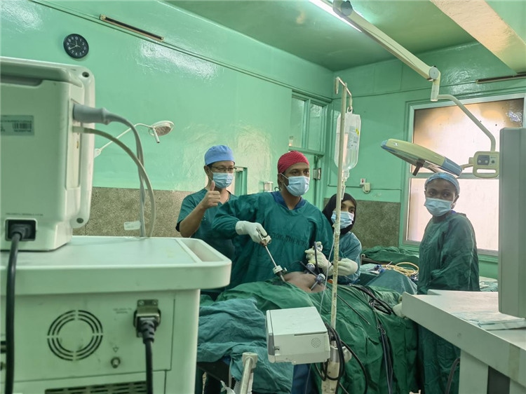 隊長蔣國慶（左一）關(guān)注當?shù)蒯t(yī)生手術(shù)情況。中國援桑醫(yī)療隊供圖
