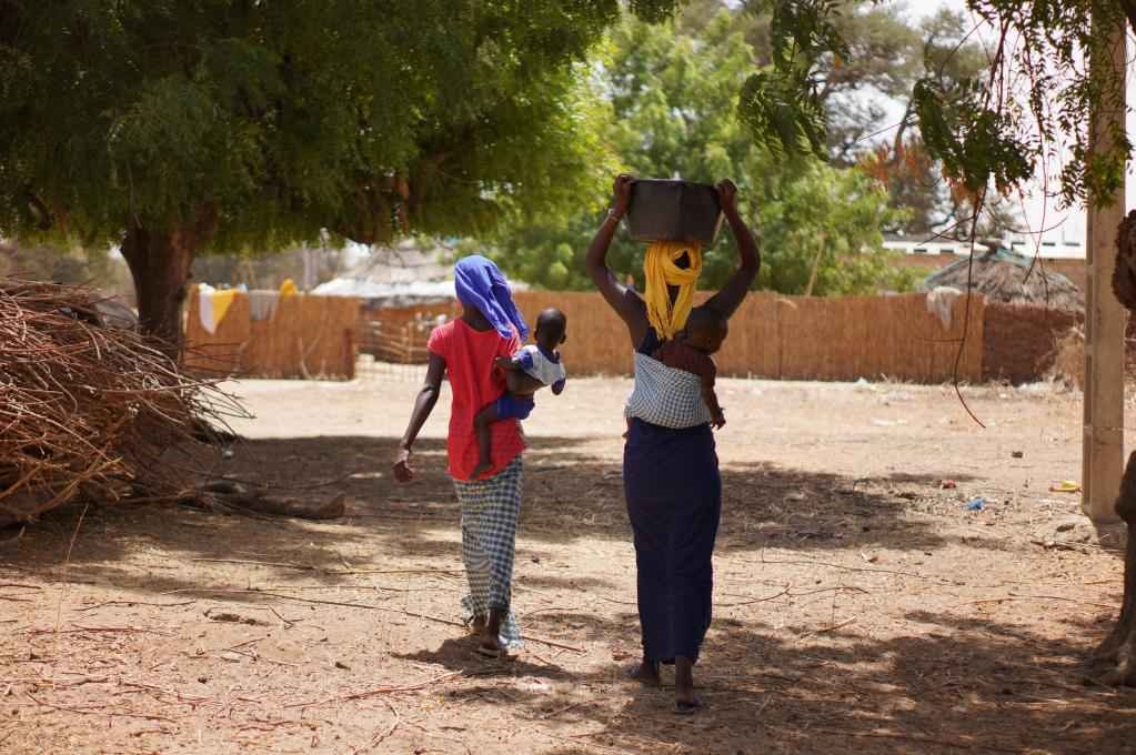 2023年3月20日，在塞內(nèi)加爾久爾貝勒區(qū)的泰內(nèi)富勒村，村民將取到的水運(yùn)回家。新華社記者 王子正 攝