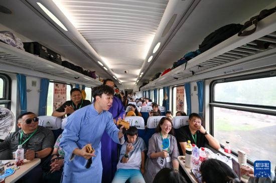 9月7日，相聲演員在S910列車上為旅客表演快板。