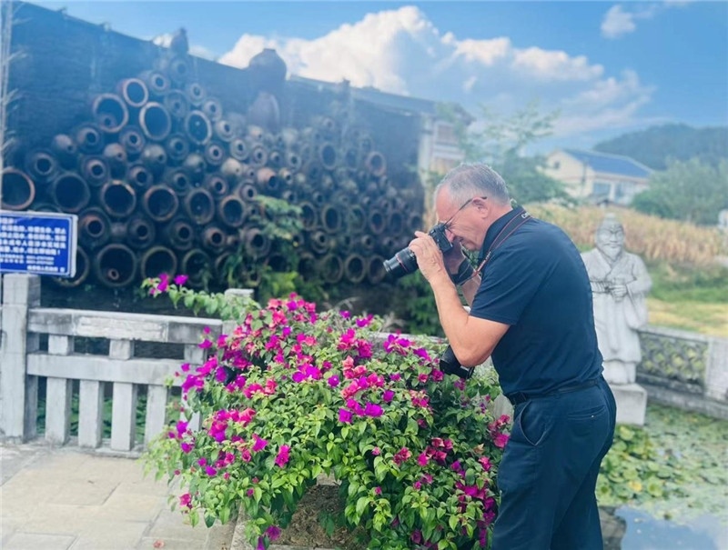 遠(yuǎn)處黔北民居錯(cuò)落有致，近處一只黑色的蝴蝶穿梭于粉紫色三角梅花叢間隙，與俄羅斯“大歐亞”總編輯弗拉基米爾·別列日內(nèi)赫的鏡頭玩起了捉迷藏，“你追我逃，不亦樂(lè)乎”。（張亞欣攝）