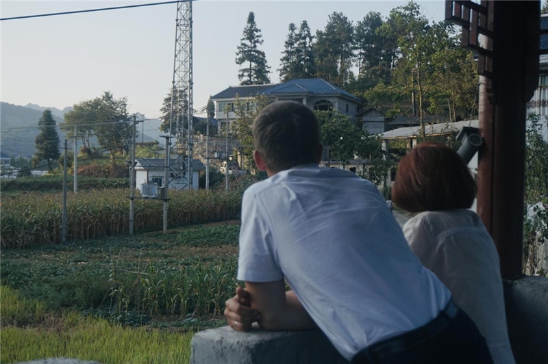 望得見(jiàn)山，看得見(jiàn)水，記得住鄉(xiāng)愁。每個(gè)人心中都有一個(gè)屬于自己的“花茂村”，在這方心田，走遍千山萬(wàn)水，鄉(xiāng)音未改鬢毛衰。吉爾吉斯斯坦《比什凱克晚報(bào)》第一副總編輯妮娜·尼奇博洛娃與《中國(guó)與俄羅斯》雜志社社長(zhǎng)奧列格·別列日內(nèi)赫攝在花茂村民居屋檐下并肩佇立，眺望山水，尋覓鄉(xiāng)愁。（李光裕攝）