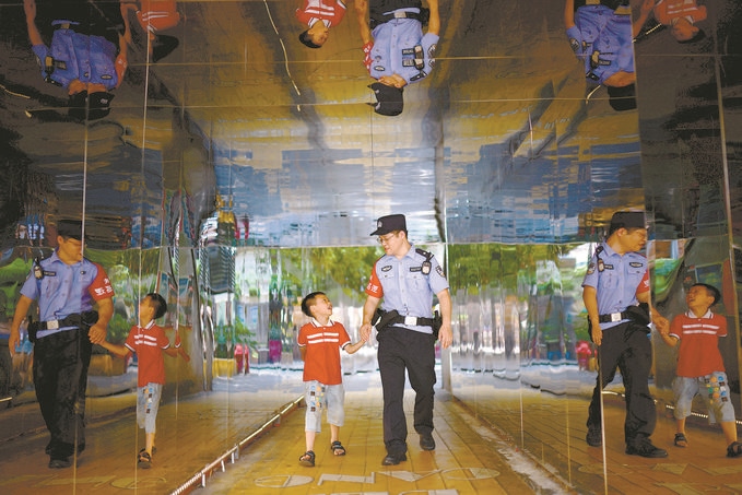 ?7月16日，重慶市公安局江北區(qū)分局一名民警在巡邏途中遇到一個(gè)獨(dú)自玩耍的小男孩，民警將其送回家。王洪平攝