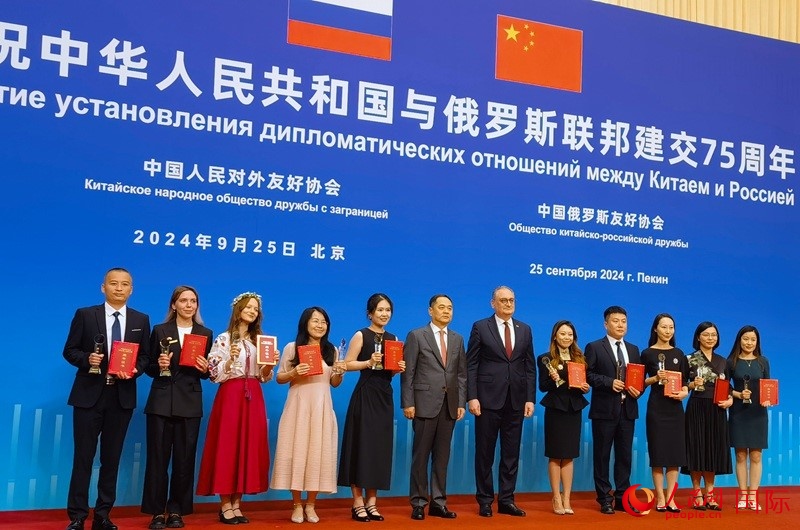 楊萬明會長和莫爾古洛夫大使為10位中俄青年友好微視頻創(chuàng)意大賽獲獎代表頒獎。人民網(wǎng)記者 李明琪攝