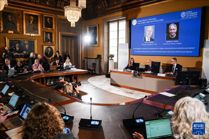 10月8日，在瑞典斯德哥爾摩舉行的2024年諾貝爾物理學獎公布現(xiàn)場，屏幕顯示獎項得主美國普林斯頓大學的約翰·霍普菲爾德和加拿大多倫多大學的杰弗里·欣頓。新華社記者 彭子洋 攝