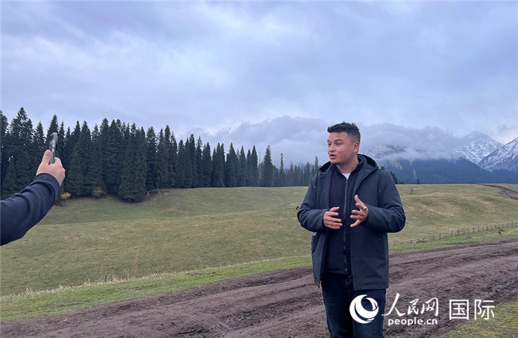 在庫爾德寧，吾買爾江被雪山美景震撼，即興錄制了短視頻作品。人民網(wǎng)記者曾書柔攝