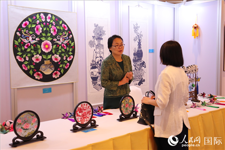 青海非遺文化傳承人向嘉賓介紹展品。人民網(wǎng)實(shí)習(xí)生姚欣可攝