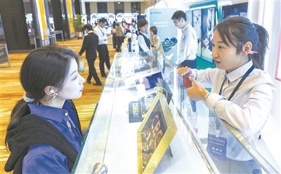 在北京麗澤商務(wù)區(qū)，工作人員（右一）介紹數(shù)字人民幣SIM卡硬錢包。新京報(bào)記者 陶冉攝