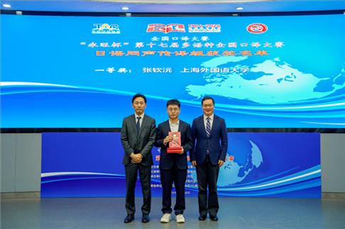 北京第二外國(guó)語學(xué)院副院長(zhǎng)鄭承軍（右一）、永旺中國(guó)投資有限公司集團(tuán)管理總部總經(jīng)理稻垣浩司（左一）為獲得日語同傳組一等獎(jiǎng)的上海外國(guó)語大學(xué)的張欽沅頒獎(jiǎng)。主辦方供圖