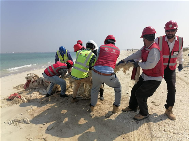 中國(guó)電建員工在撿拾海灘垃圾。中國(guó)電建供圖