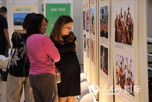 圖為當(dāng)?shù)赜^眾在圖片展現(xiàn)場(chǎng)欣賞作品，張志文攝