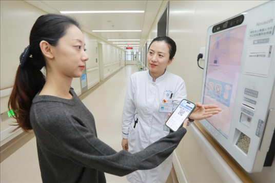 醫(yī)護(hù)人員引導(dǎo)患者在自助機(jī)前辦理自助入院手續(xù)。圖片來源：山東第一醫(yī)科大學(xué)第二附屬醫(yī)院