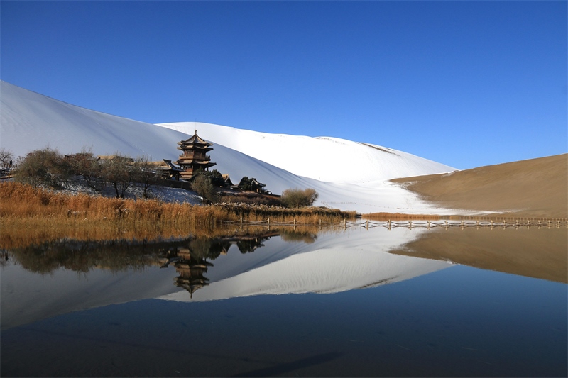 鳴沙山月牙泉景區(qū)雪景。敦煌市委宣傳部供圖，張曉亮攝