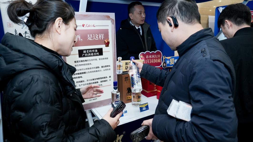 白酒展位負責人在為嘉賓介紹。張新攝