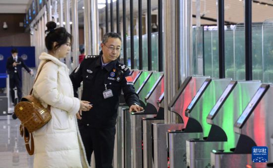 1月2日，大興機場邊檢站警察指導旅客使用自助出境設備。新華社記者 李欣 攝