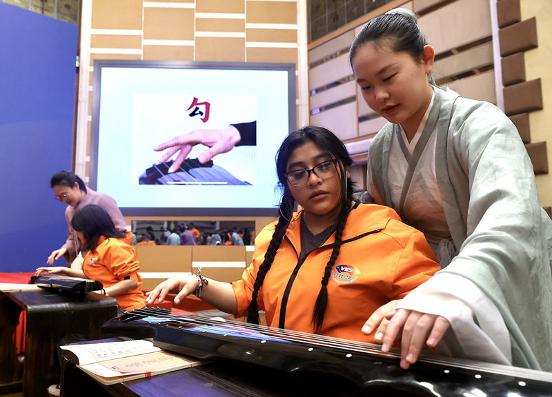 2024年3月20日，美國華盛頓州中學生代表團北京大學交流活動在北京大學英杰交流中心舉行。圖為來自華盛頓州的中學生體驗古琴。