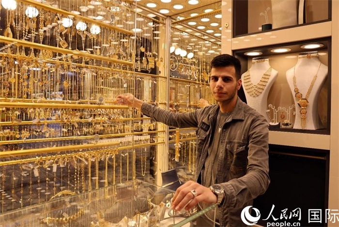 一名銷售員展示黃金飾品。人民網(wǎng) 伊納斯·易卜拉欣攝