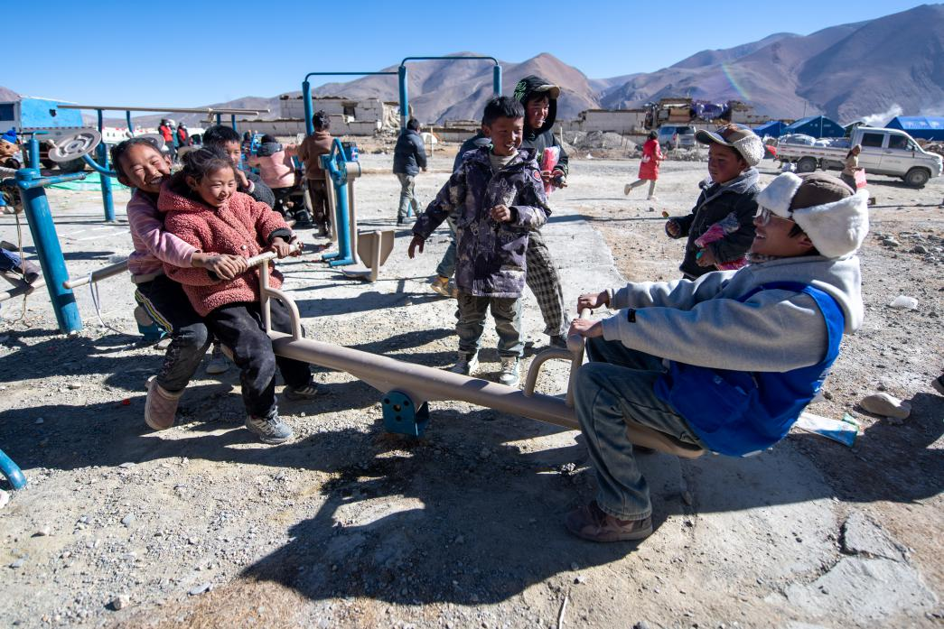 1月11日，在定日縣措果鄉(xiāng)塘仁村安置點，西藏星光社會工作服務中心志愿者和孩子們一起玩耍，進行災后心理疏導。人民網(wǎng)記者 翁奇羽攝